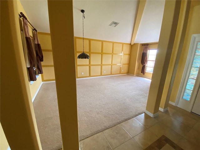 unfurnished room with a towering ceiling, beamed ceiling, and carpet floors