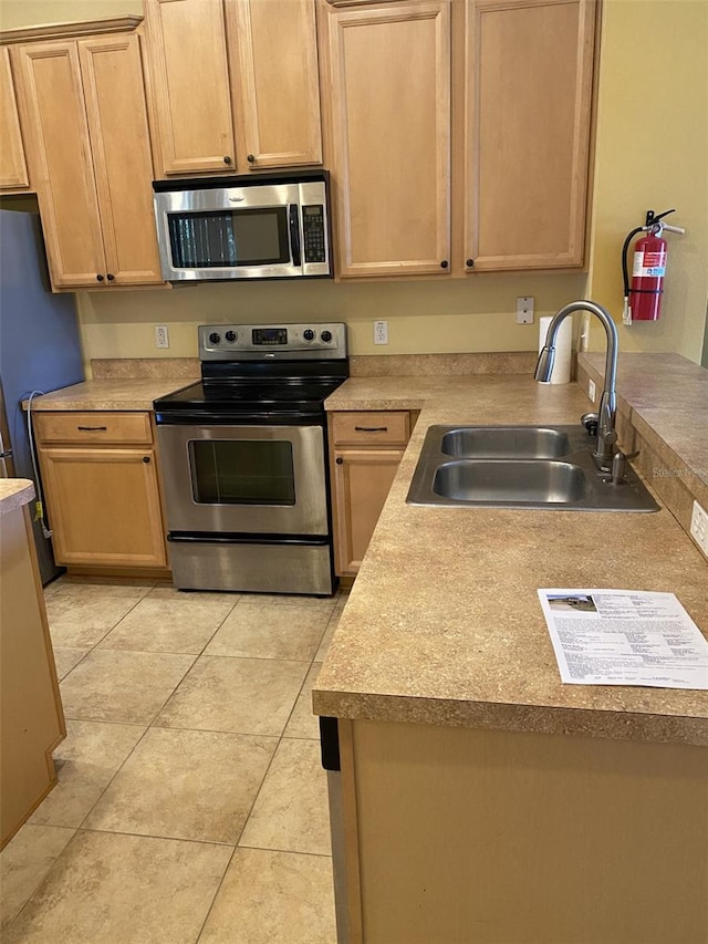 kitchen with sink, stainless steel appliances, and light brown cabinets