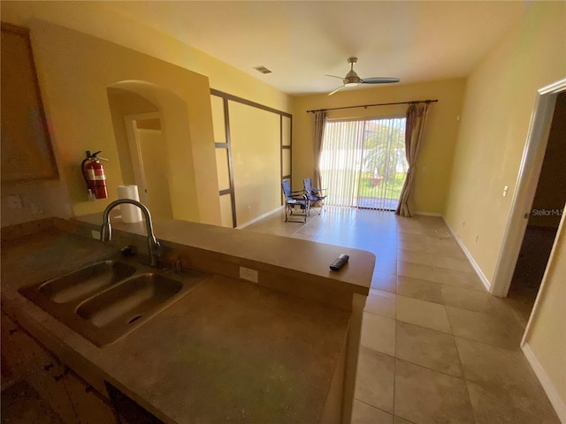 kitchen with ceiling fan, light tile patterned floors, sink, and kitchen peninsula