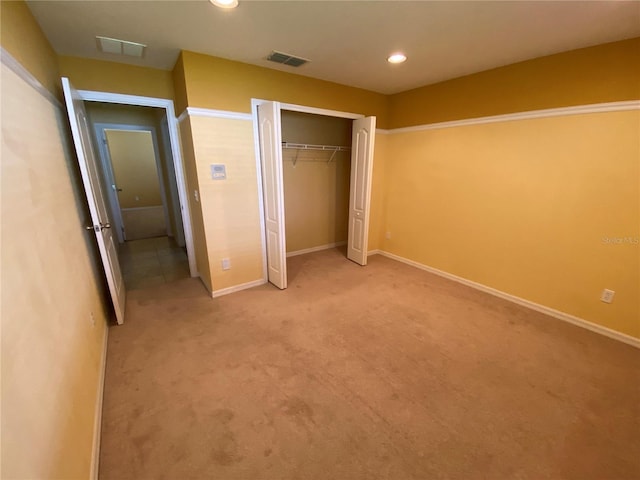 unfurnished bedroom with light carpet and a closet