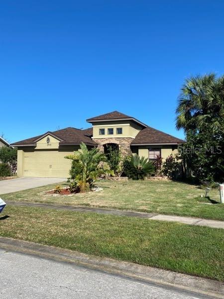 view of front of home with a garage and a front lawn