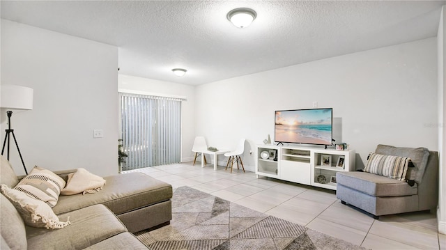 living room featuring a textured ceiling and light tile floors