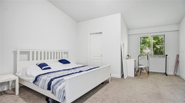 bedroom featuring light carpet and vaulted ceiling