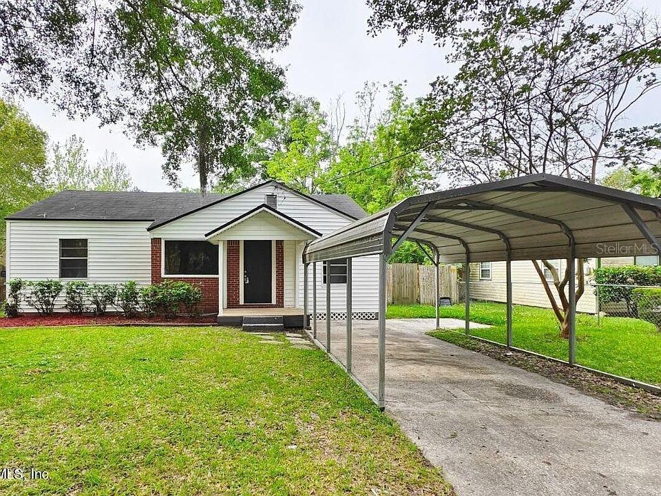 view of front of home featuring a front yard and a carport