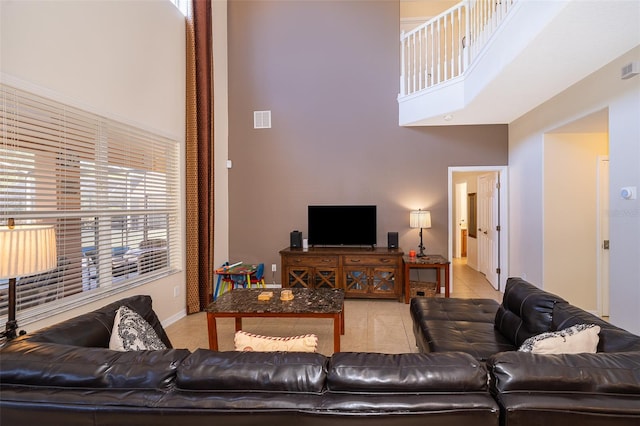 living room featuring light tile floors and a high ceiling