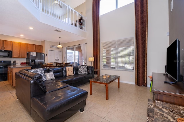 living room featuring a high ceiling and light tile floors