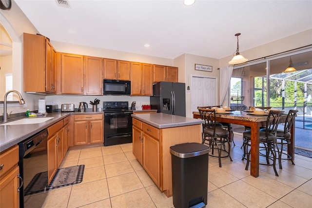 kitchen featuring a center island, hanging light fixtures, black appliances, light tile floors, and sink