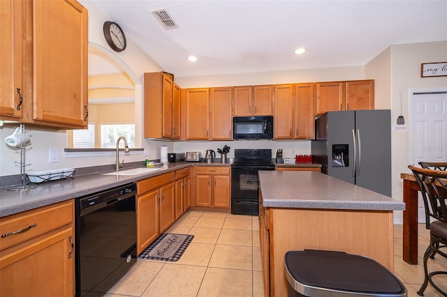 kitchen featuring sink, light tile floors, a kitchen island, and black appliances