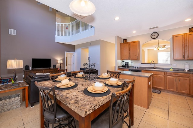 dining room with sink, light tile floors, and a notable chandelier