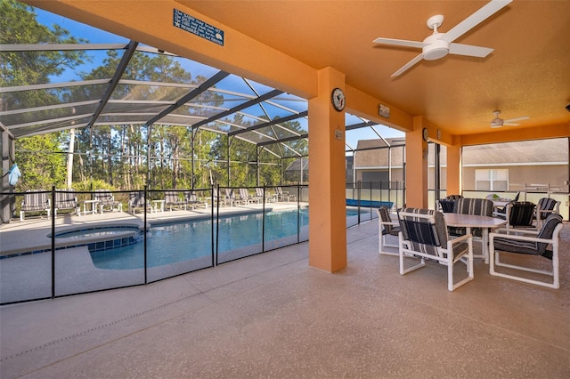 view of pool with a patio area, ceiling fan, and glass enclosure