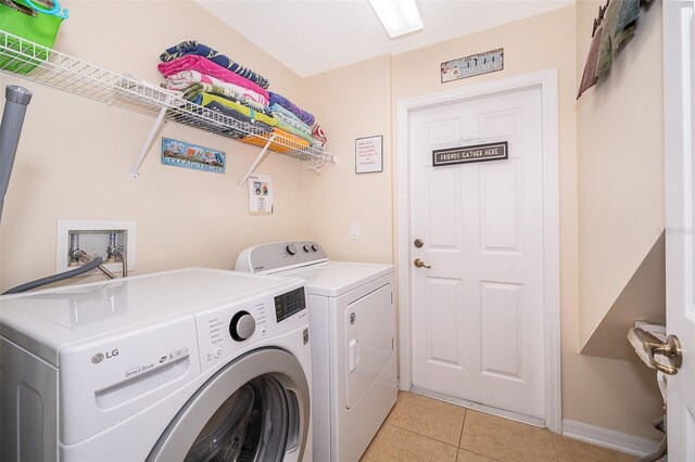 washroom featuring independent washer and dryer, hookup for a washing machine, and light tile floors