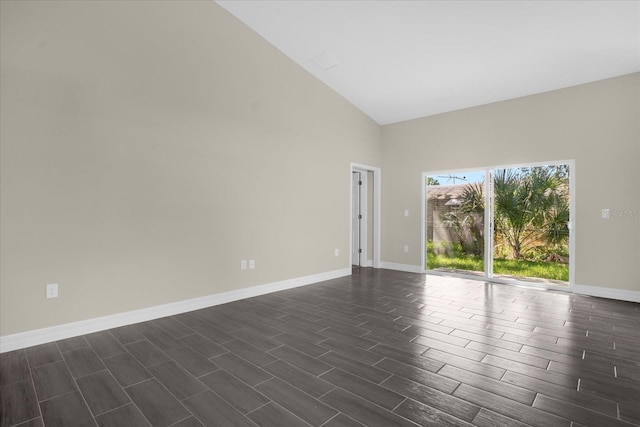 spare room featuring high vaulted ceiling and dark hardwood / wood-style flooring