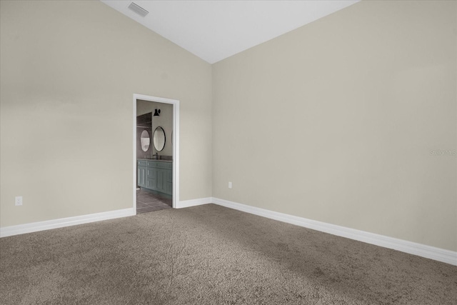 unfurnished room with high vaulted ceiling and dark colored carpet