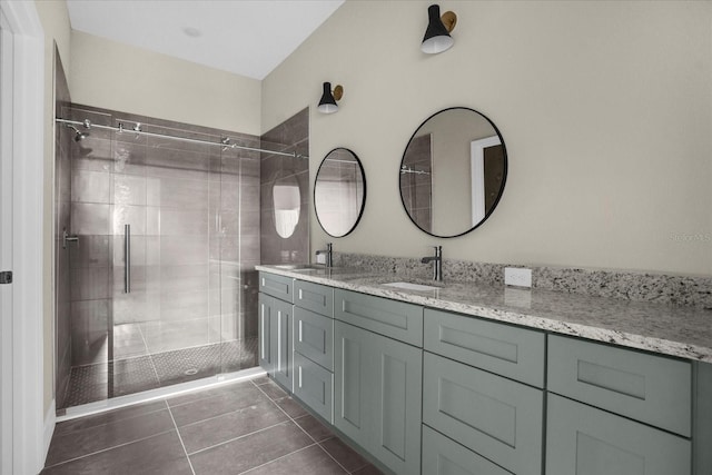 bathroom with a shower with shower door, dual bowl vanity, and tile flooring