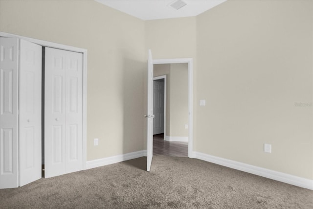 unfurnished bedroom featuring a closet and dark carpet