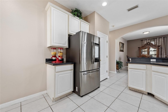 kitchen with white cabinets, stainless steel fridge, and light tile patterned floors