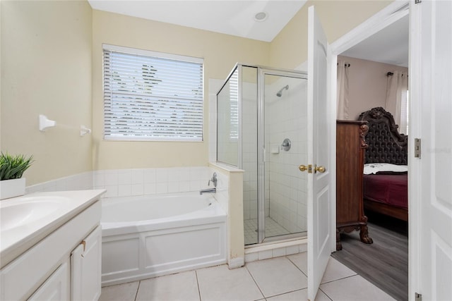 bathroom with tile patterned flooring, independent shower and bath, and vanity