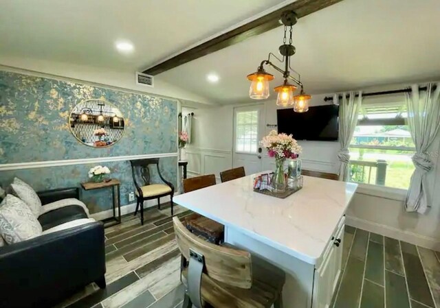 dining area featuring lofted ceiling with beams, a notable chandelier, a wealth of natural light, and dark hardwood / wood-style floors