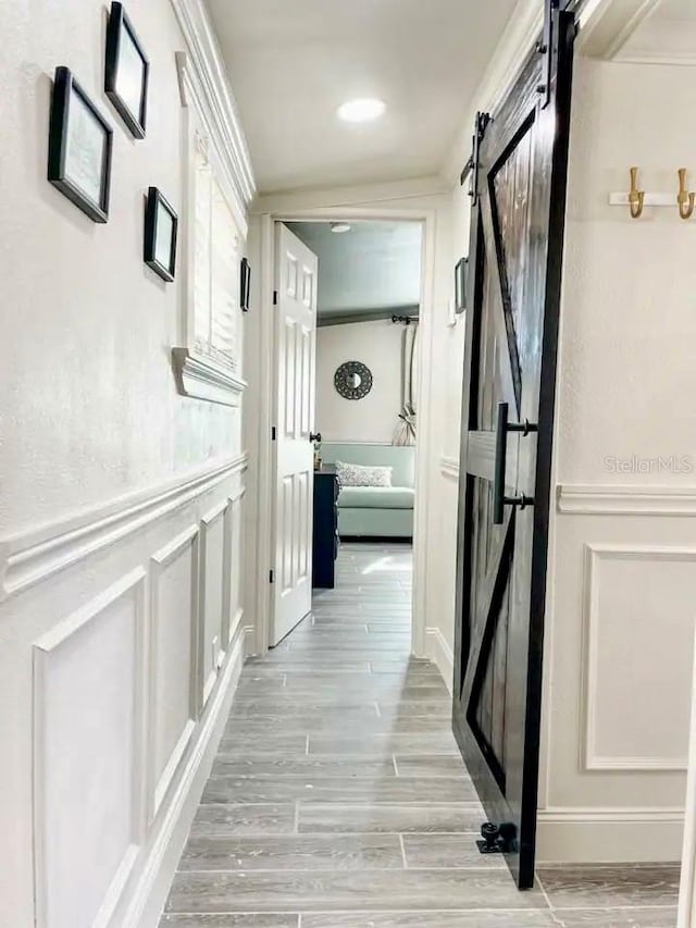 corridor featuring light hardwood / wood-style flooring and a barn door