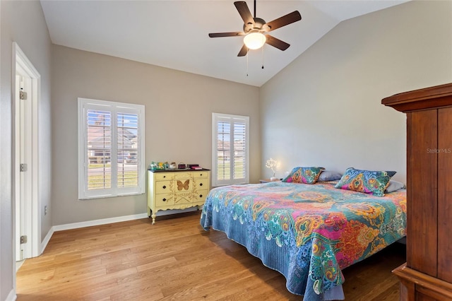 bedroom with ceiling fan, light hardwood / wood-style floors, and vaulted ceiling