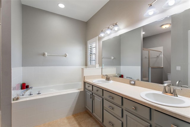 full bathroom featuring separate shower and tub, double vanity, tile floors, and toilet