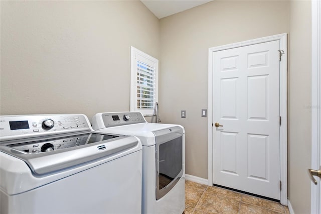 washroom with light tile floors and washing machine and dryer