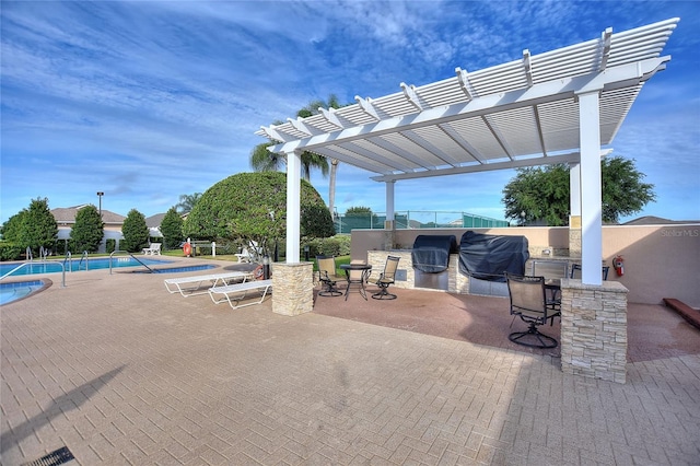 view of terrace with exterior kitchen, an outdoor bar, a pergola, and a fenced in pool