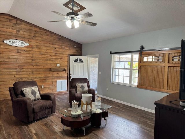 living room with dark wood-type flooring, wooden walls, ceiling fan, and vaulted ceiling