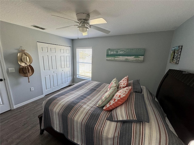 bedroom featuring dark hardwood / wood-style floors, ceiling fan, a closet, and a textured ceiling