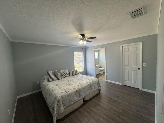 bedroom with a textured ceiling, ornamental molding, dark hardwood / wood-style flooring, ensuite bath, and ceiling fan