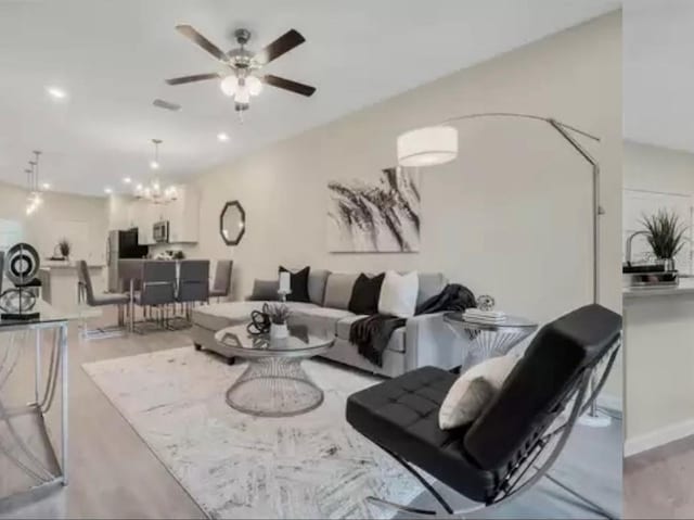 living room featuring recessed lighting and ceiling fan with notable chandelier