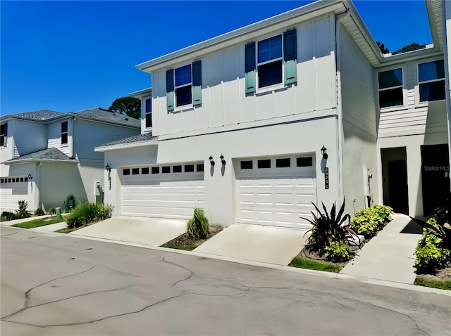 view of front facade with a garage, concrete driveway, and board and batten siding