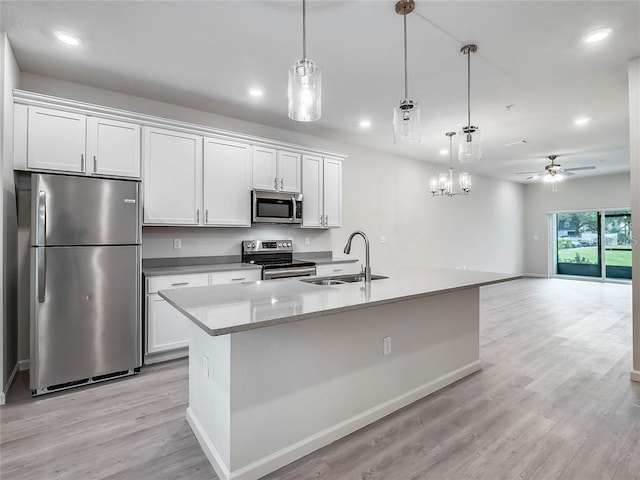 kitchen with appliances with stainless steel finishes, a sink, and white cabinetry