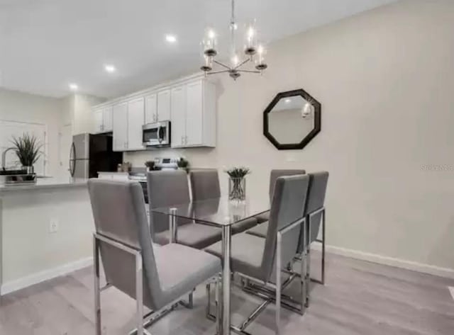 dining room with a chandelier, light wood-style floors, recessed lighting, and baseboards