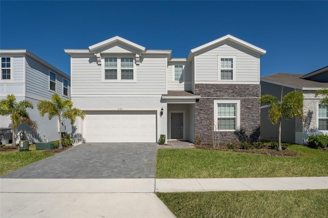 view of front of house featuring central air condition unit, a garage, and a front lawn