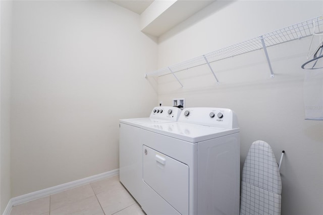 clothes washing area featuring light tile flooring, washer and dryer, and hookup for a washing machine