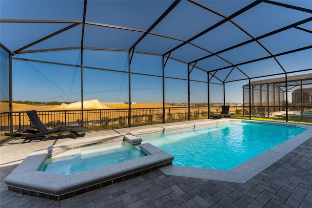 view of swimming pool featuring a lanai, a patio area, and an in ground hot tub