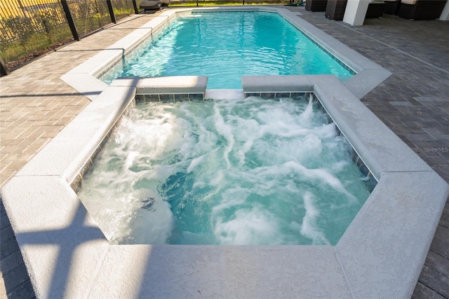 view of pool featuring an in ground hot tub