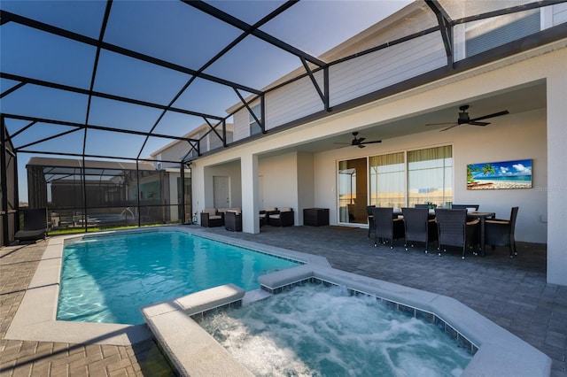 view of pool with ceiling fan, glass enclosure, a patio area, and an in ground hot tub