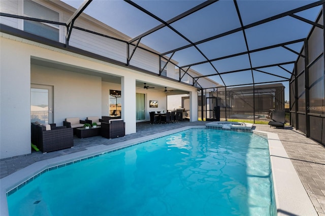 view of swimming pool featuring glass enclosure, an in ground hot tub, ceiling fan, an outdoor living space, and a patio area