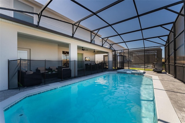 view of pool featuring a patio, glass enclosure, ceiling fan, and an in ground hot tub