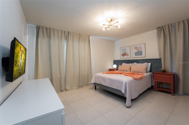 bedroom featuring light tile floors and a textured ceiling