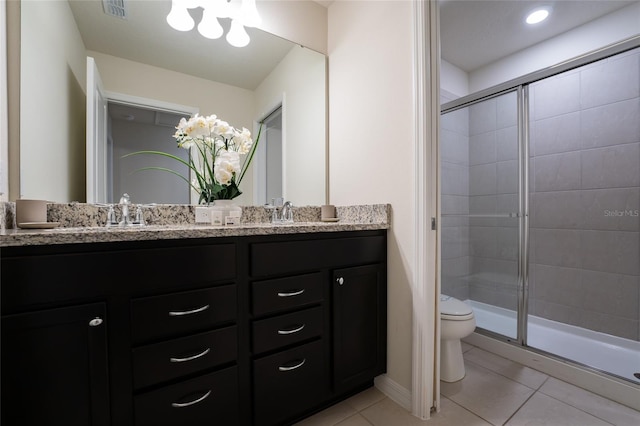 bathroom featuring tile flooring, dual sinks, toilet, an enclosed shower, and oversized vanity