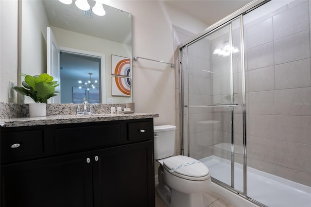 bathroom featuring toilet, large vanity, a chandelier, tile flooring, and an enclosed shower