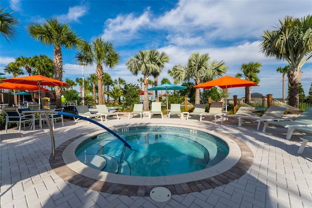 view of swimming pool featuring a hot tub and a patio