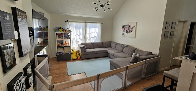 living room with wood-type flooring, high vaulted ceiling, and a notable chandelier