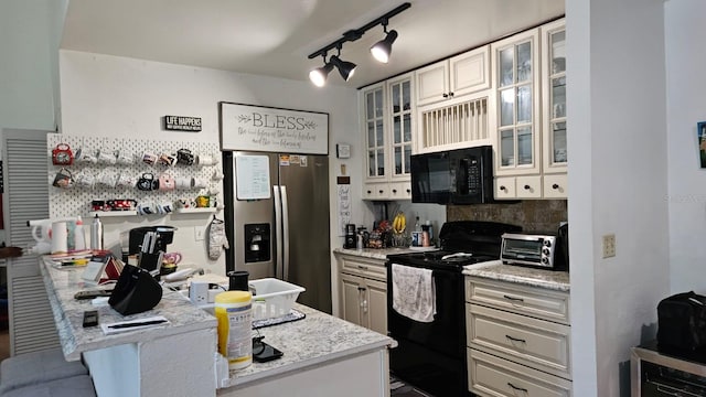 kitchen with rail lighting, light stone counters, beverage cooler, and black appliances