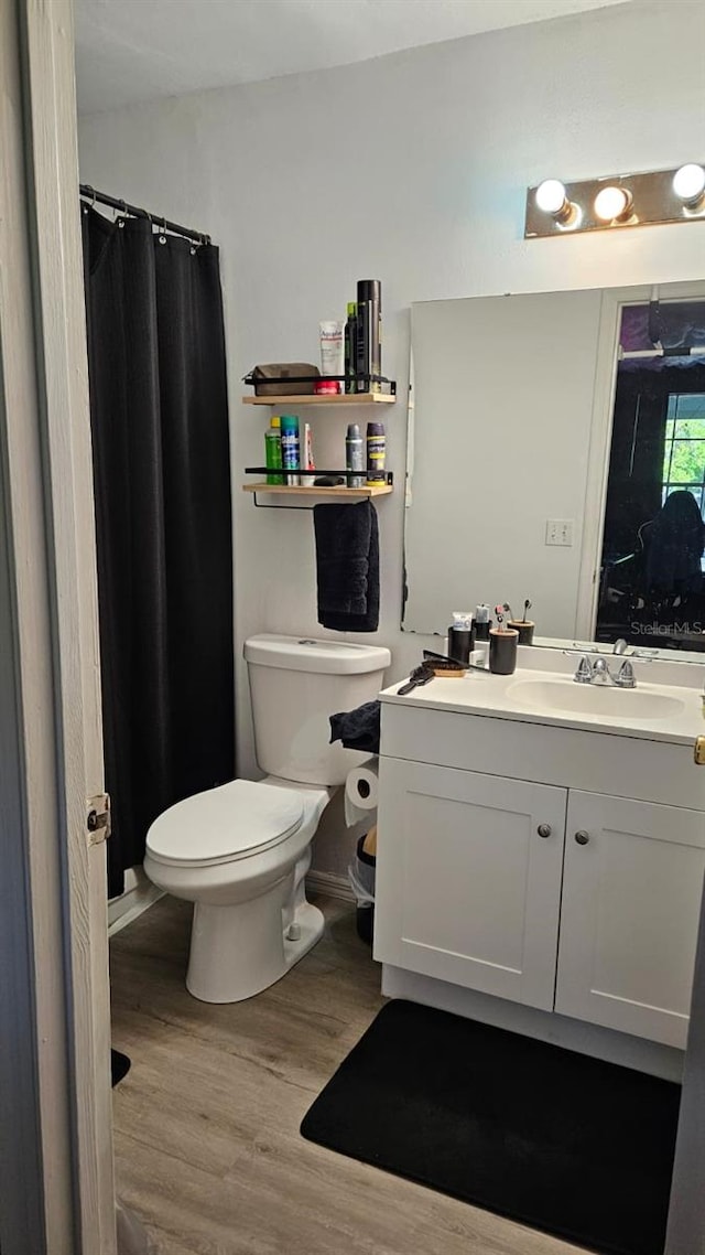 bathroom with vanity, toilet, and hardwood / wood-style flooring