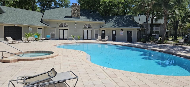 view of swimming pool with a hot tub and a patio area