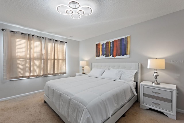 bedroom with a textured ceiling and light colored carpet